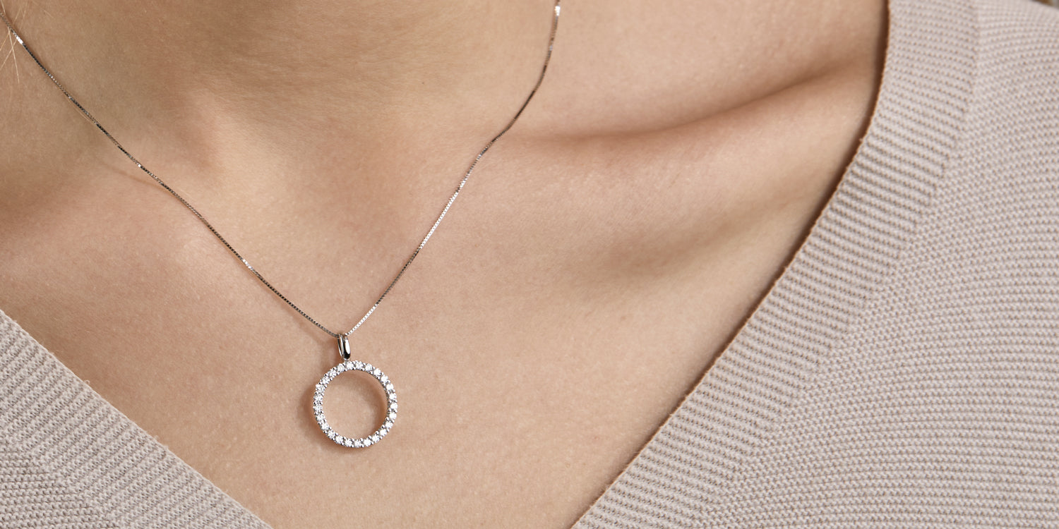 Silberne Halskette mit Zirkonia-Anhänger in Kreisform am Hals einer Dame